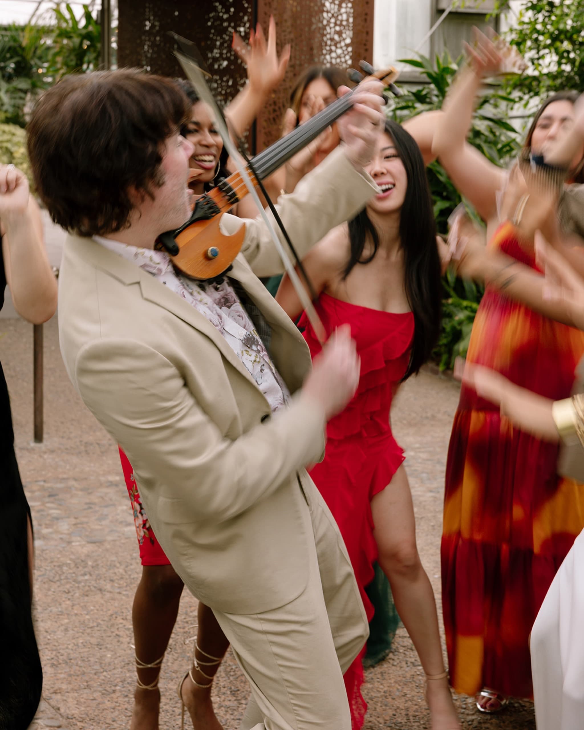 Electric violinist playing among dancing guests
