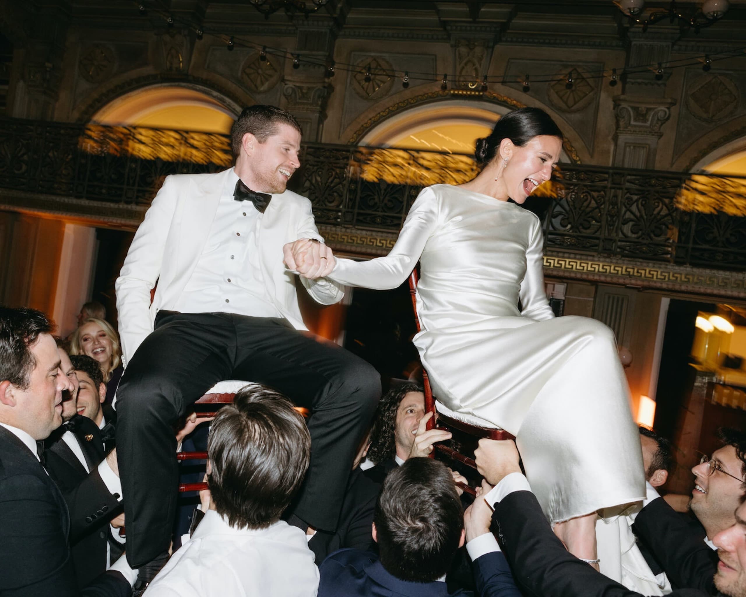 Newlyweds lifted on chairs during the hora